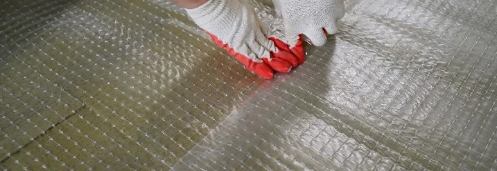 Person beim Verlegen einer Trittschalldämmung